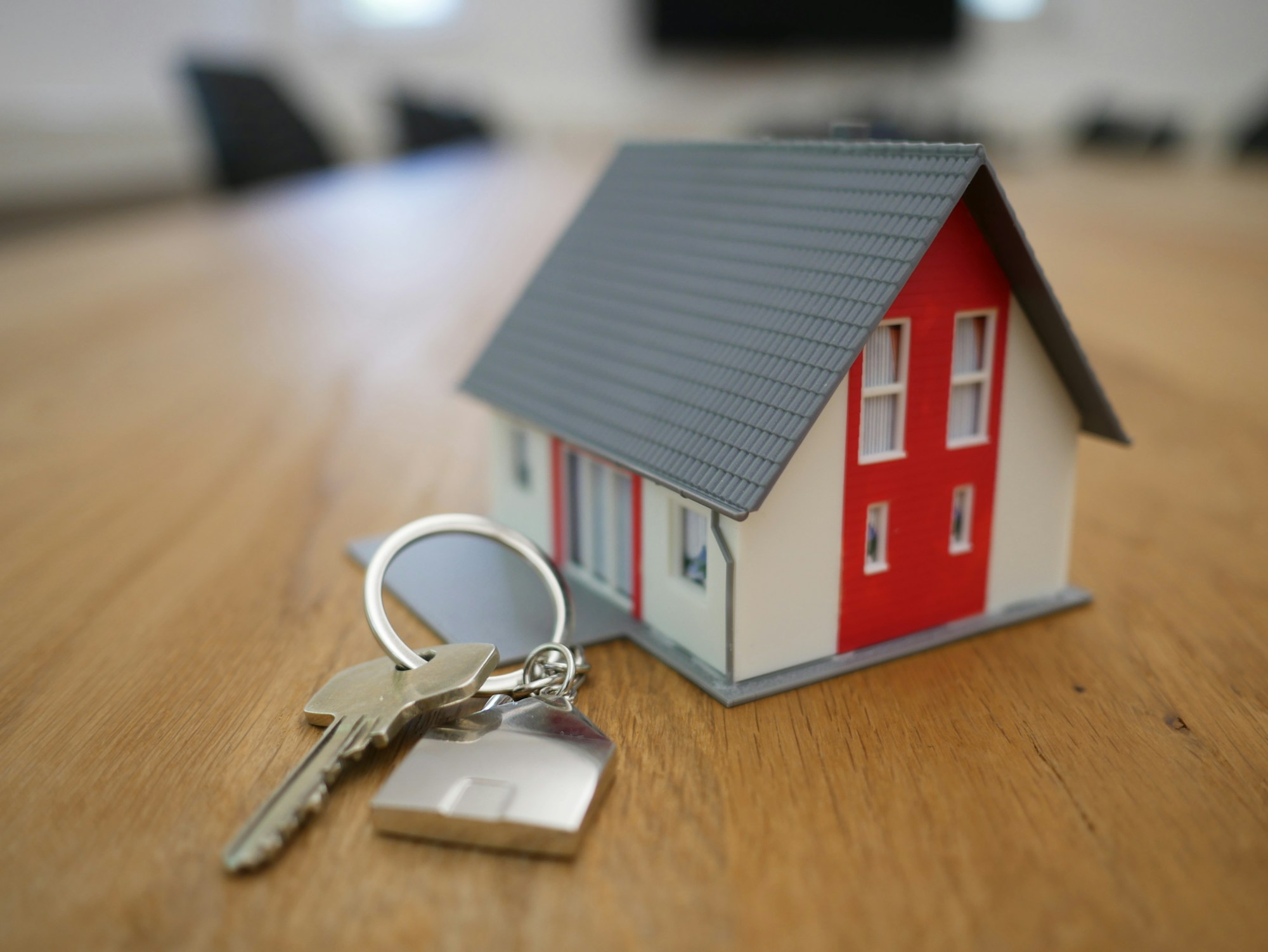 Keys being handed over in front of a home