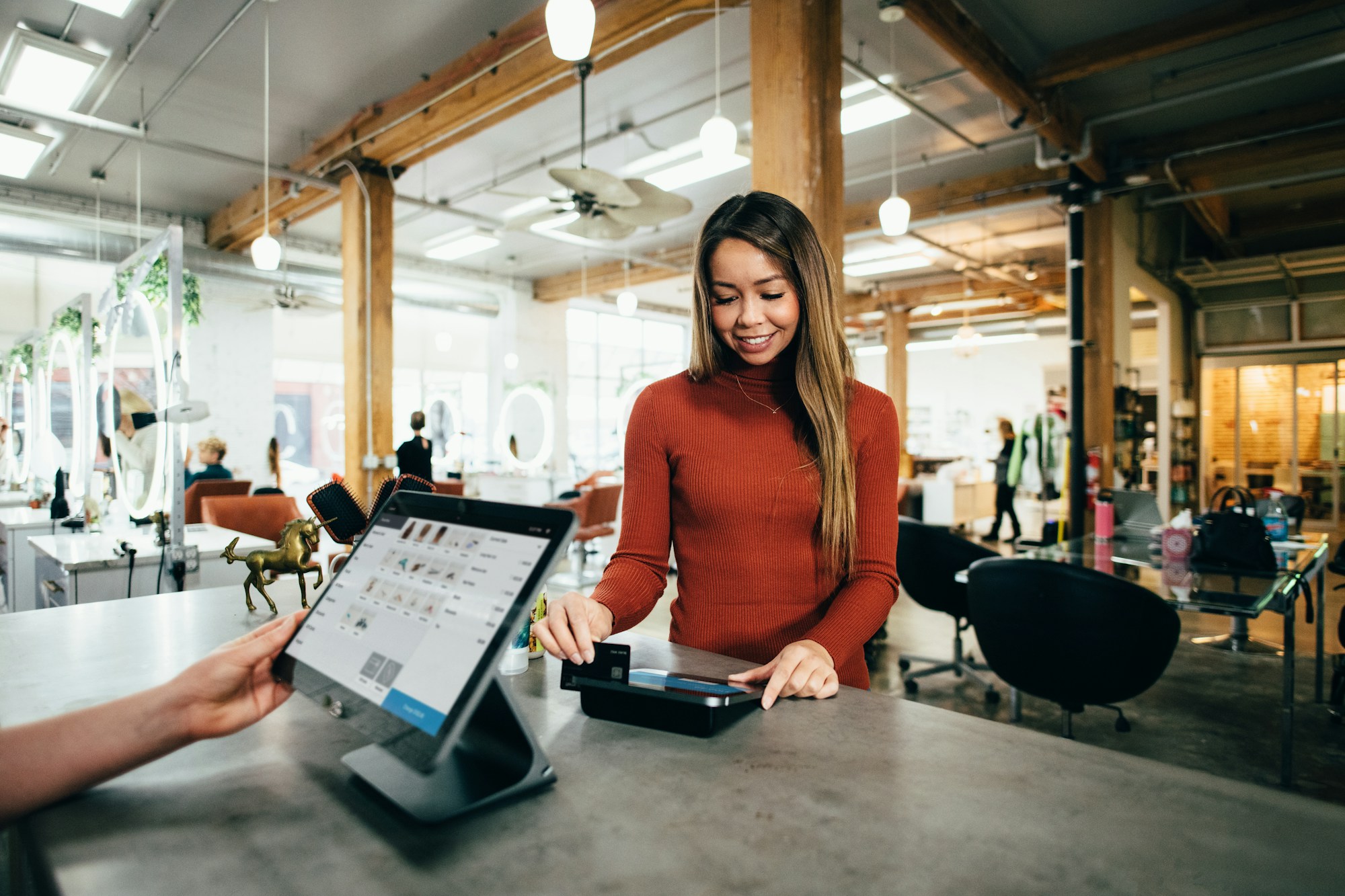 Small business owner ringing up a sale at the counter